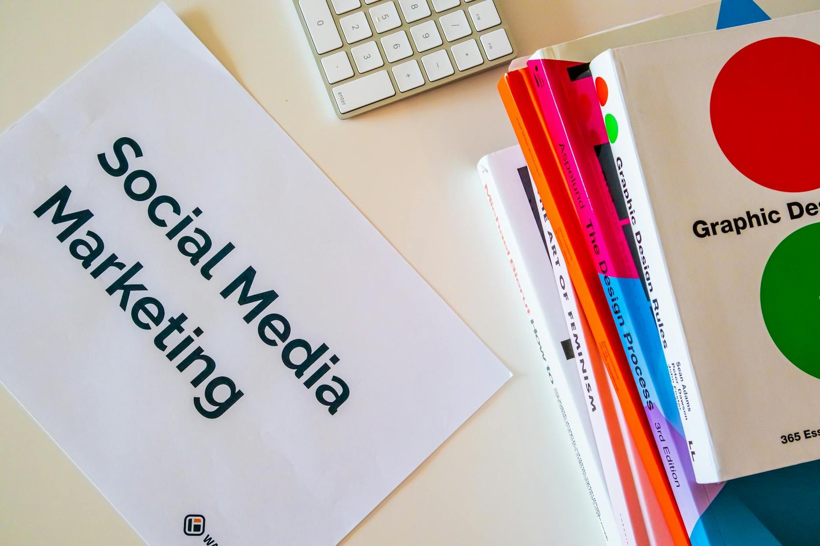 close up of a pile of books and a piece of paper saying social media marketing lying on a desk